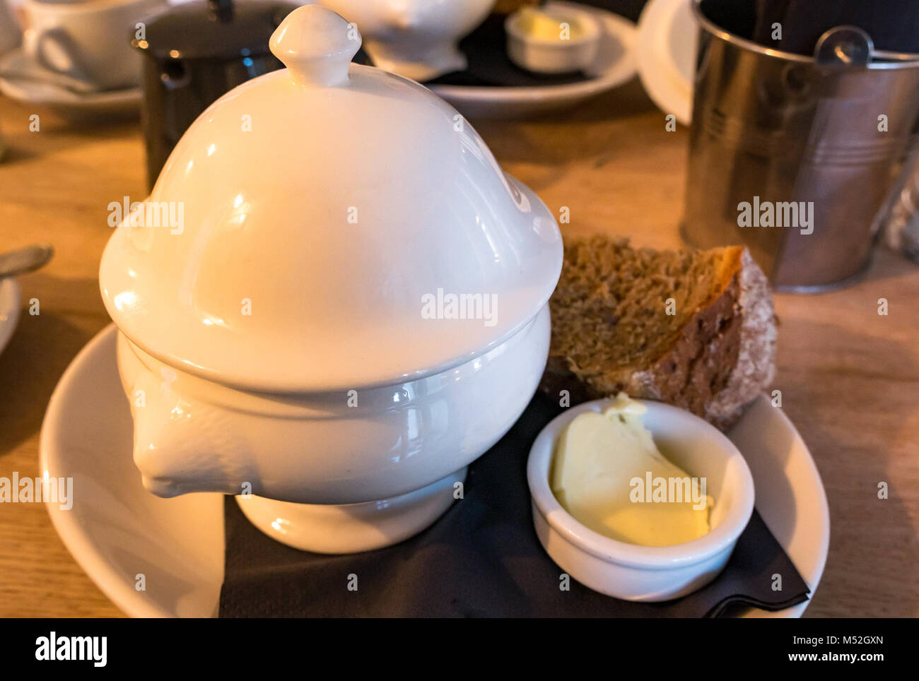 Cullen skink sopa servida en una terrina de cerámica blanca con pan y mantequilla en Rockpool Cafe, Cullen, Moray en Escocia, Reino Unido Foto de stock