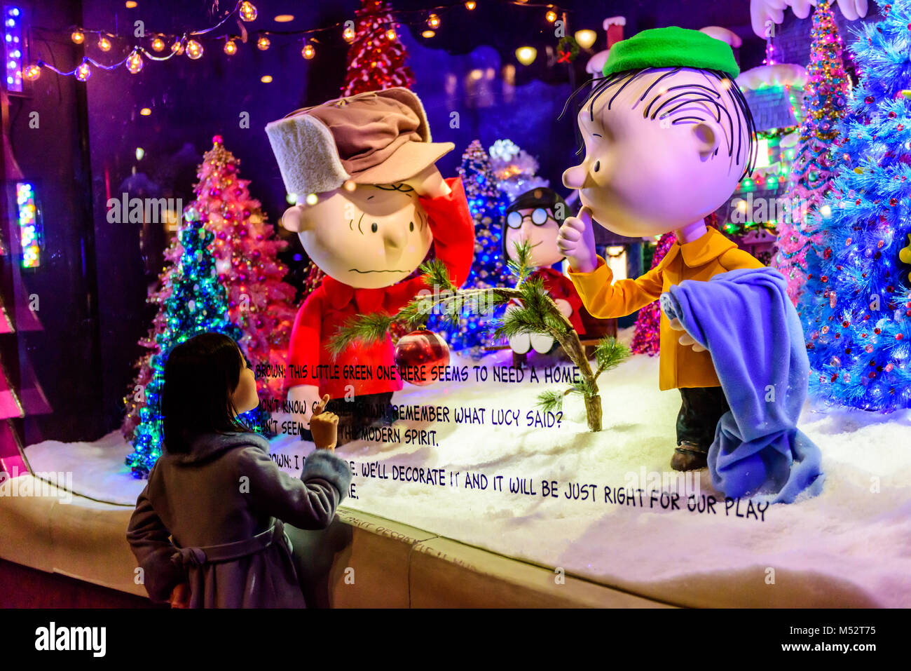 Niña mira con asombro a Charlie Brown Christmas escaparate en el buque insignia de los grandes almacenes Macy's en Nueva York, NY, EUA. Foto de stock