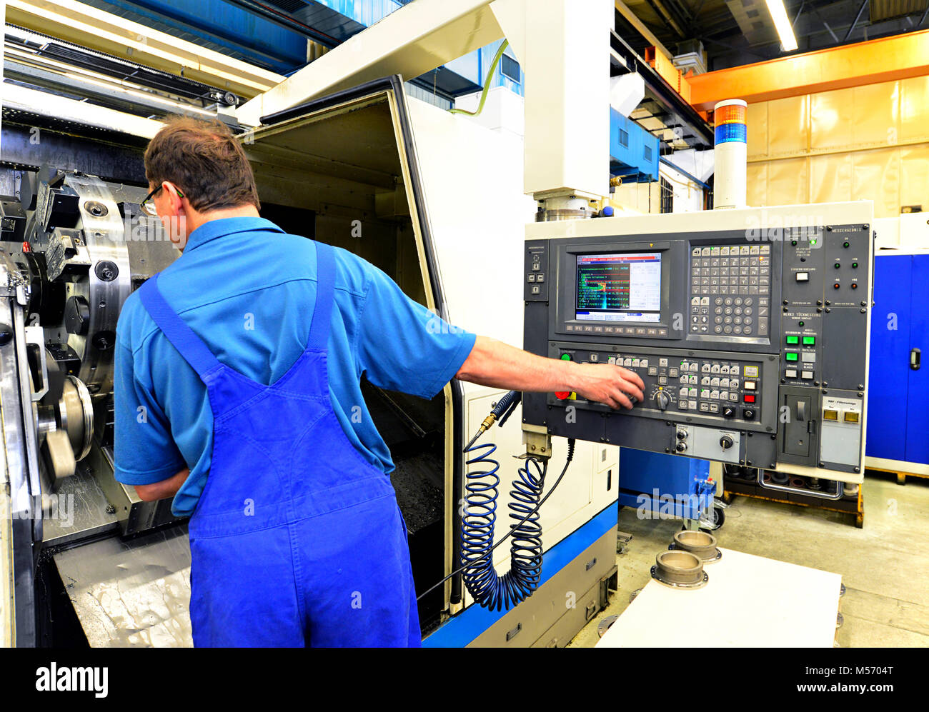 Trabajador de la fábrica opera una fresadora cnc para la producción de  componentes mecánicos Fotografía de stock - Alamy