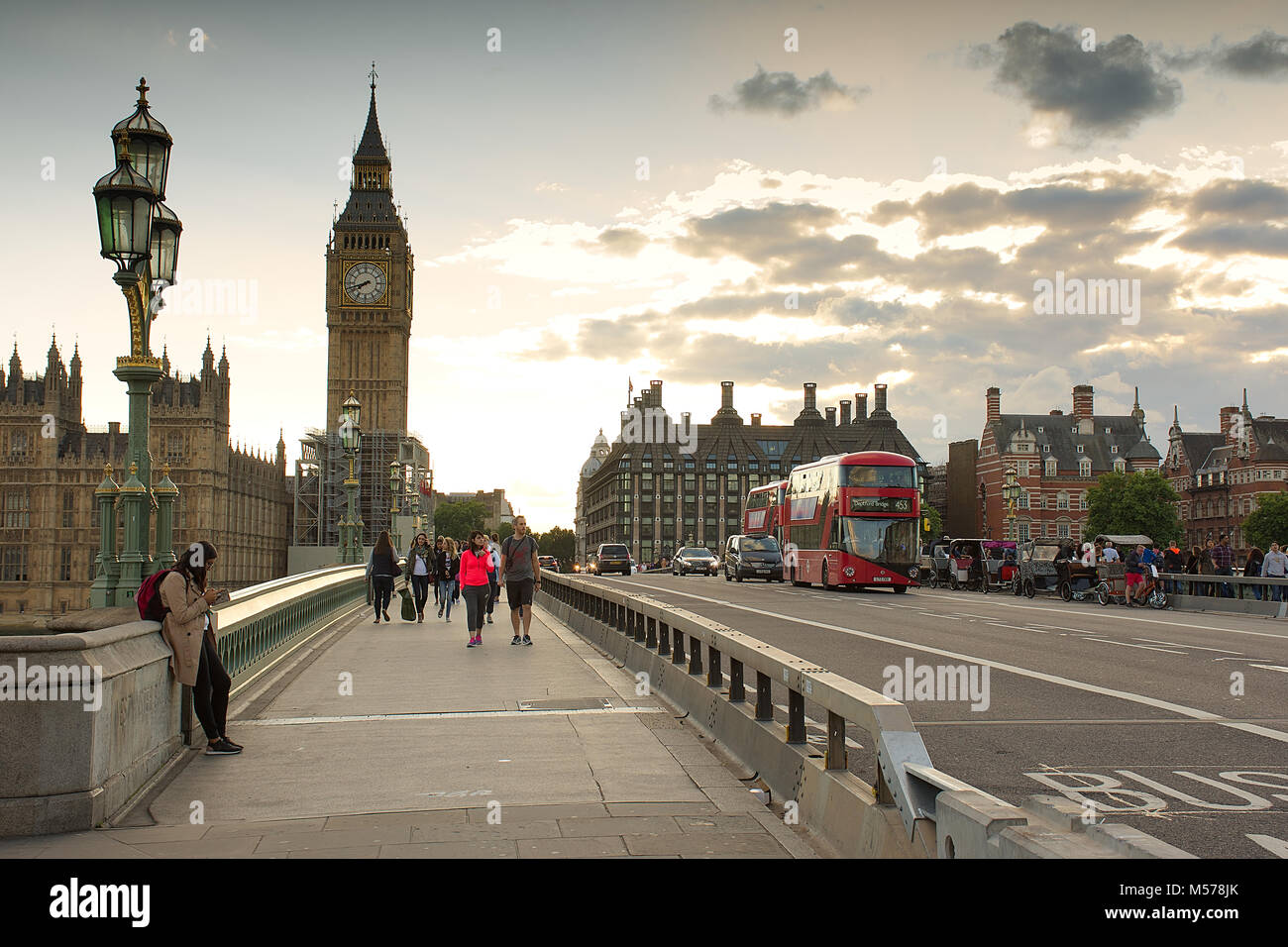 La gente en el puente de Westminster en Londres en verano tarde.Big Ben ,sol y red double decker bus en background.Londres, Reino Unido. Foto de stock