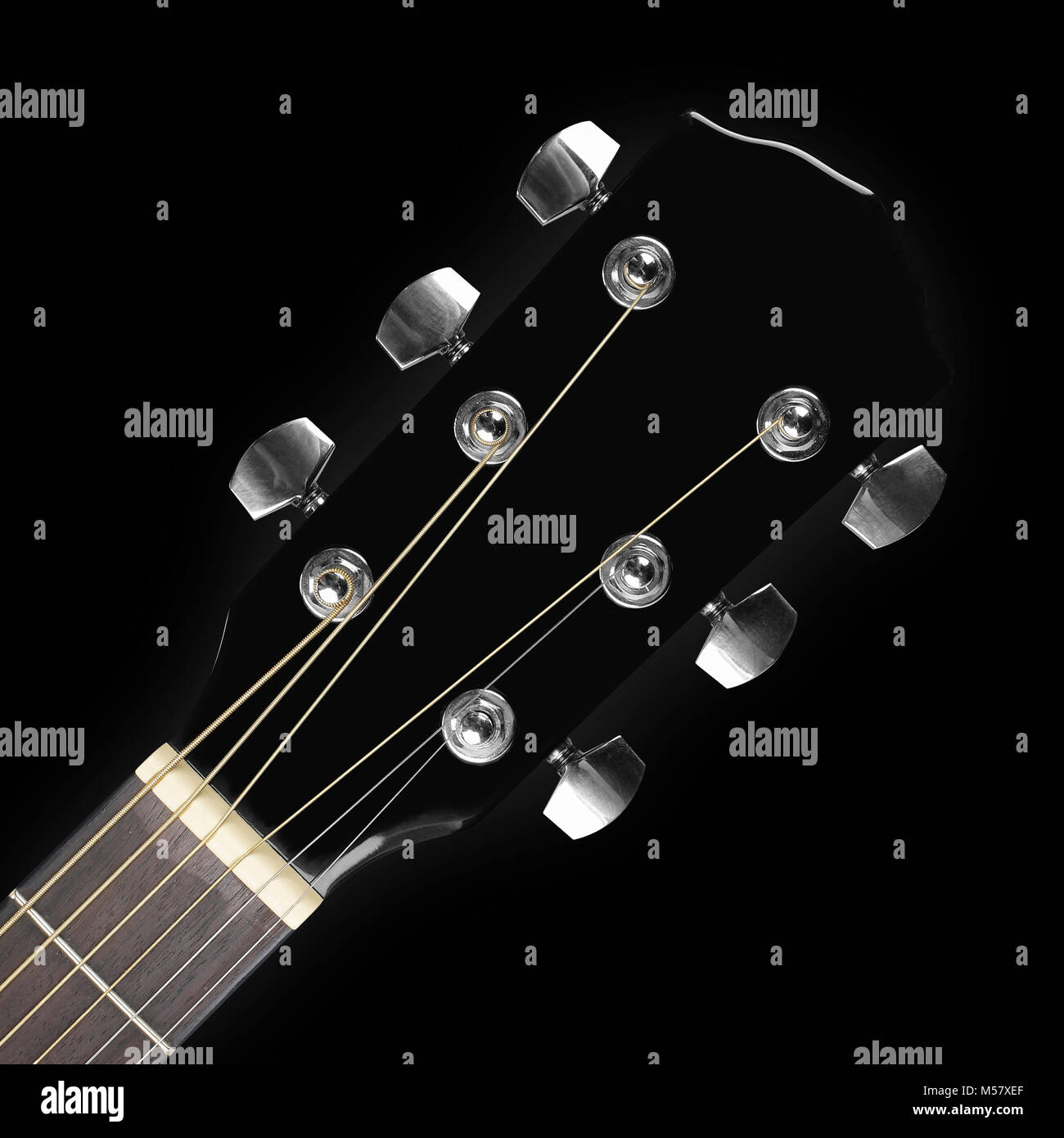 Instrumento musical - clavijero peghead guitarra acústica negra sobre un  fondo negro Fotografía de stock - Alamy