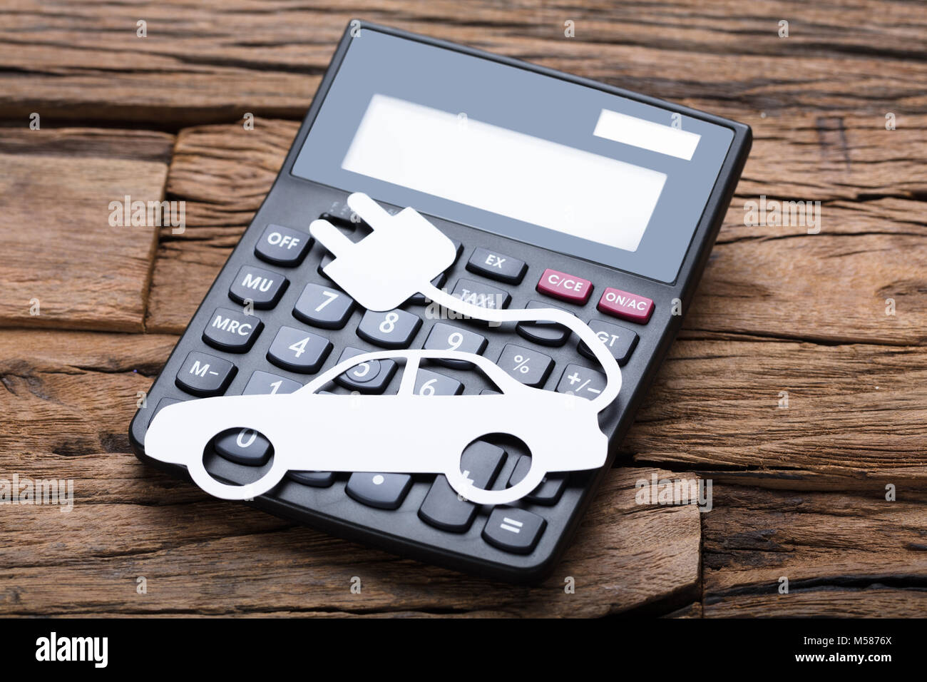 Un alto ángulo de visualización de papel coche eléctrico en calculadora en  mesa de madera Fotografía de stock - Alamy