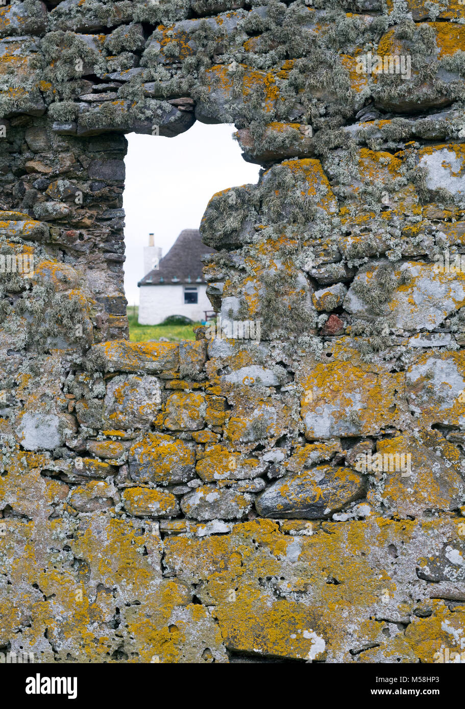 Choza de piedra blanca de Howmore Gatliff Hostel,fotografiados fro cercano monasterio del siglo XIII, la isla de South Uist, Hébridas Exteriores, Escocia, Reino Unido Foto de stock