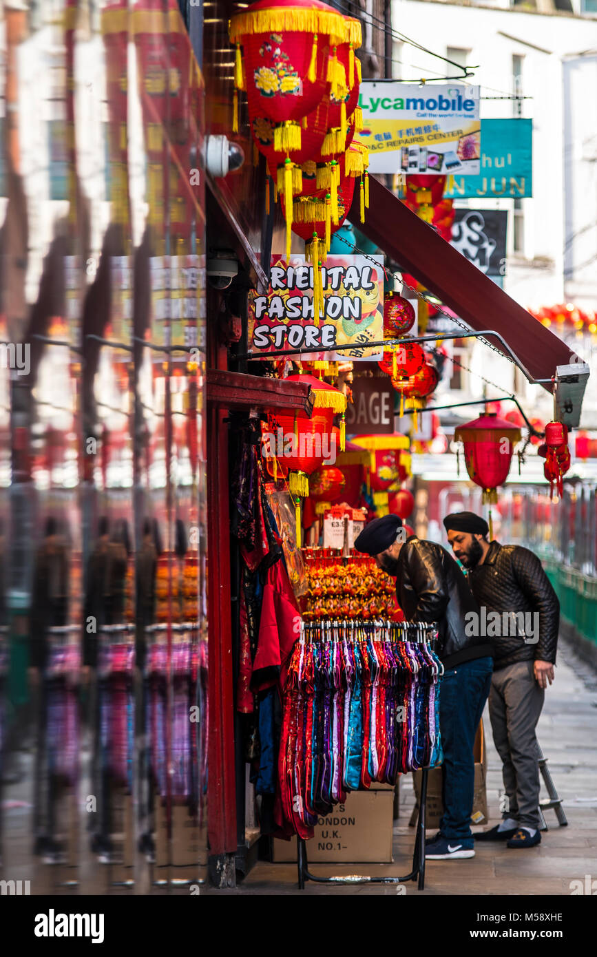 Tienda de modas orientales en Chinatown, Soho, Londres. Ropa de colores brillantes. Linternas chinas. Rampa de ropa Foto de stock