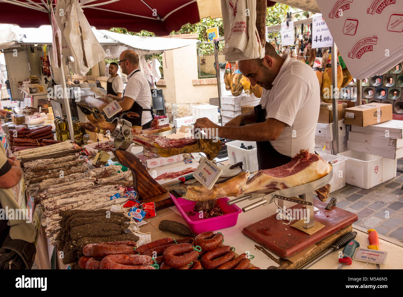 Un puesto titular rebanar jamón ibérico en el mercado semanal en La Bisbal d'Empordà, Baix Emporda, Cataluña, España Foto de stock
