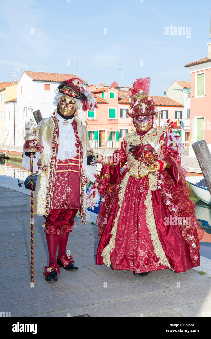 Carnaval de Venecia, Burano, Venecia, Véneto, Italia. Par de Trajes  clásicos Roja posando en Fondamenta della Giudecca entre las coloridas  casas en B Fotografía de stock - Alamy