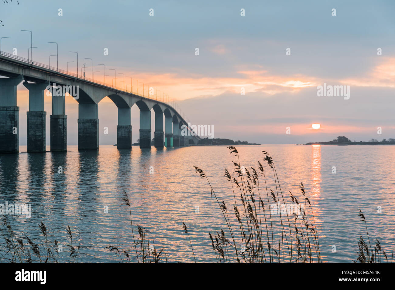 Amanecer por el puente de Öland, conecta la isla sueca de Öland en el Mar Báltico, Suecia continental Foto de stock