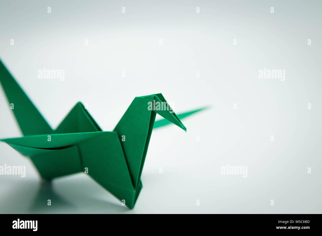 Pájaro verde simple origami aislado en blanco Foto de stock