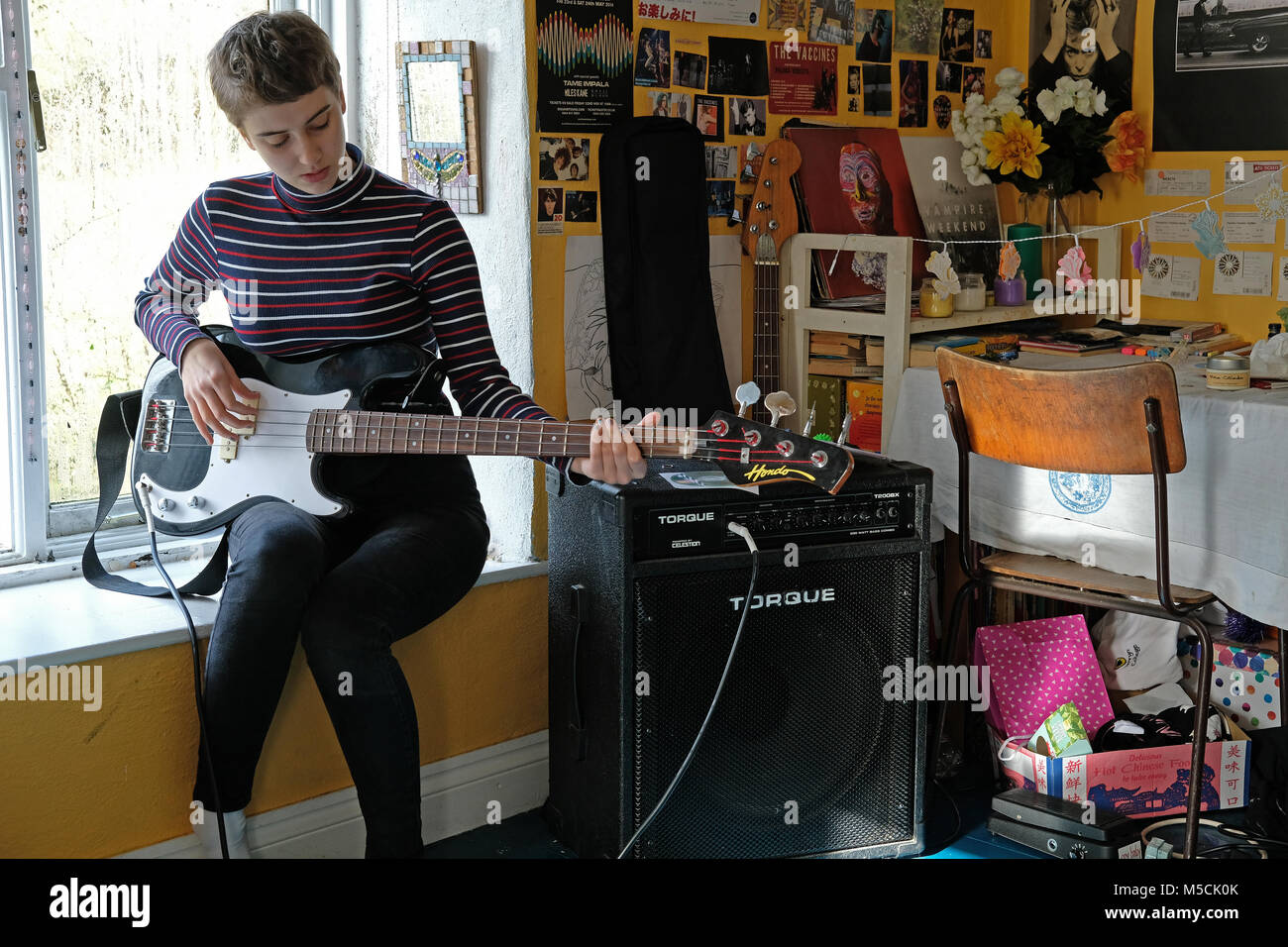 Adolescente practicando su instrumento en su dormitorio. Foto de stock