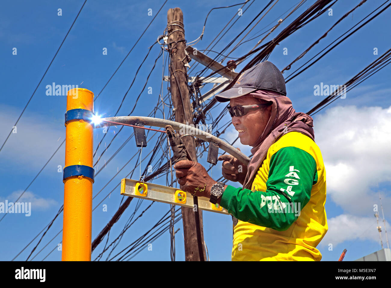 Un juez de línea de soldadura al arco filipinos calle signo vistiendo sólo gafas de sol sin cualquier otras prendas protectoras en Puerto Princesa, Palawan, Filipinas. Foto de stock