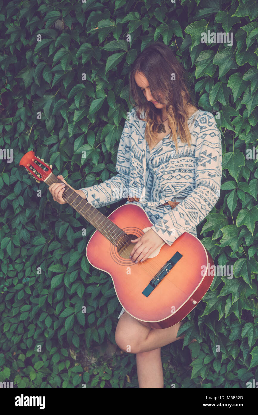 Retrato de mujer elegante tocando la guitarra acústica en la naturaleza.  Conceptos de la moda y la música Fotografía de stock - Alamy