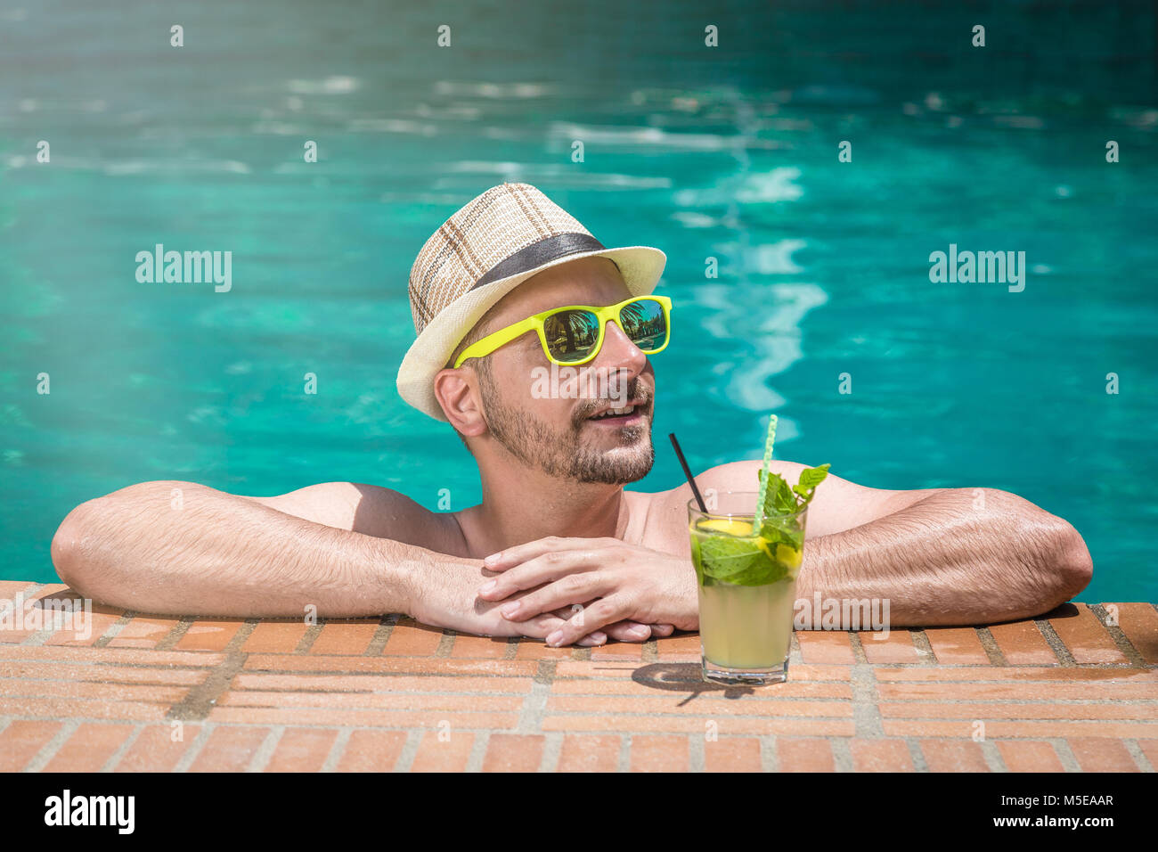 el hombre con gafas de sol negras está en la piscina en sus
