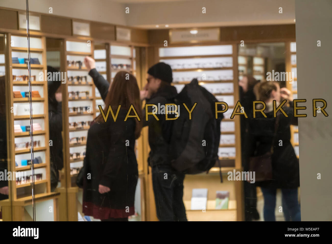 Clientes en la Warby Parker anteojos store en la Grand Central Terminal en Nueva York el viernes, 16 de febrero de 2018. Warby Parker anunció que planea llegar a 100 tiendas este año desde el 64 que actualmente opera. El comerciante de gafas está siguiendo los pasos de otras empresas de comercio electrónico en la búsqueda de que necesitan una presencia física al servicio y atraer clientes. (Â© Richard B. Levine) Foto de stock