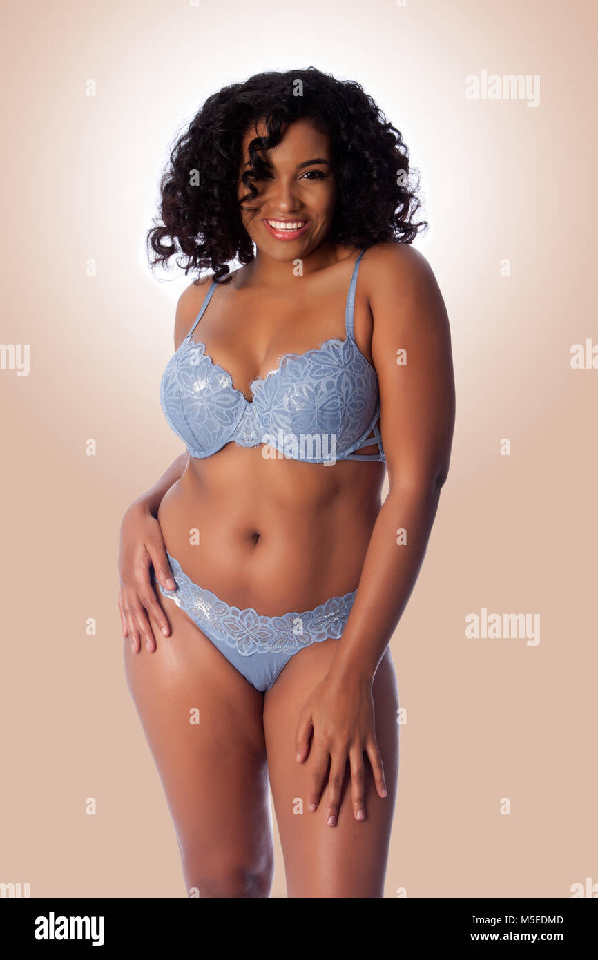 Plus size feliz hermosa mujer sexy con el pelo rizado con una luz azul  lenceria sujetador y tanga ropa interior Fotografía de stock - Alamy