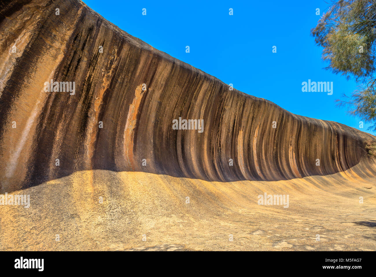 Paisaje de Wave Rock una formación rocosa natural que tiene la forma de una altura Rompiendo las olas del océano, Hyden, Australia Occidental. Wave Rock es parte de Hyden Rock en Hyden Wildlife Park. Día soleado cielo azul. Foto de stock