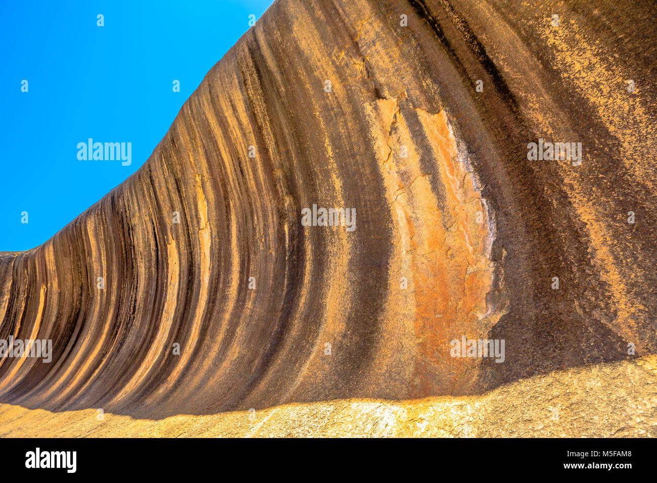 Colores dorados de Wave Rock una formación rocosa que se forma como una gran ola del océano, Hyden, Australia Occidental. Wave Rock es parte de Hyden Rock en Hyden Wildlife Park. Blue Sky. Vista en perspectiva. Foto de stock