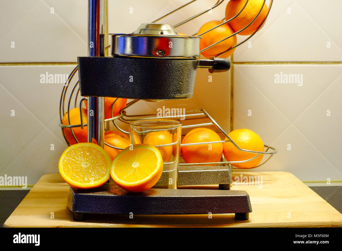 Preparar zumo de naranja recién exprimido con un exprimidor mecánico en una  cocina natural antecedentes Fotografía de stock - Alamy