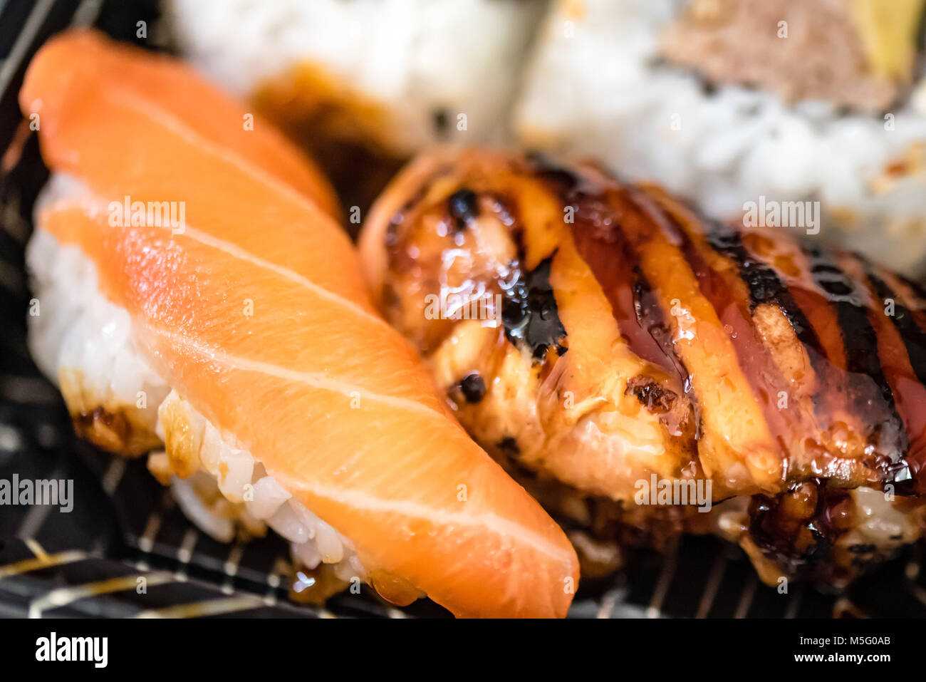 Mezcla de pescado fresco, plato de sushi comida macro fotografía, el enfoque selectivo. La comida japonesa, salmón, caballa, atún, arroz de sushi, rosa, blanco, primer plano. Foto de stock