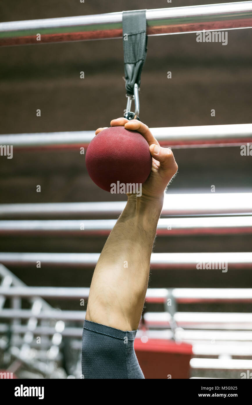 El hombre muscular sosteniendo un balón agarre para tirar hacia arriba Foto de stock