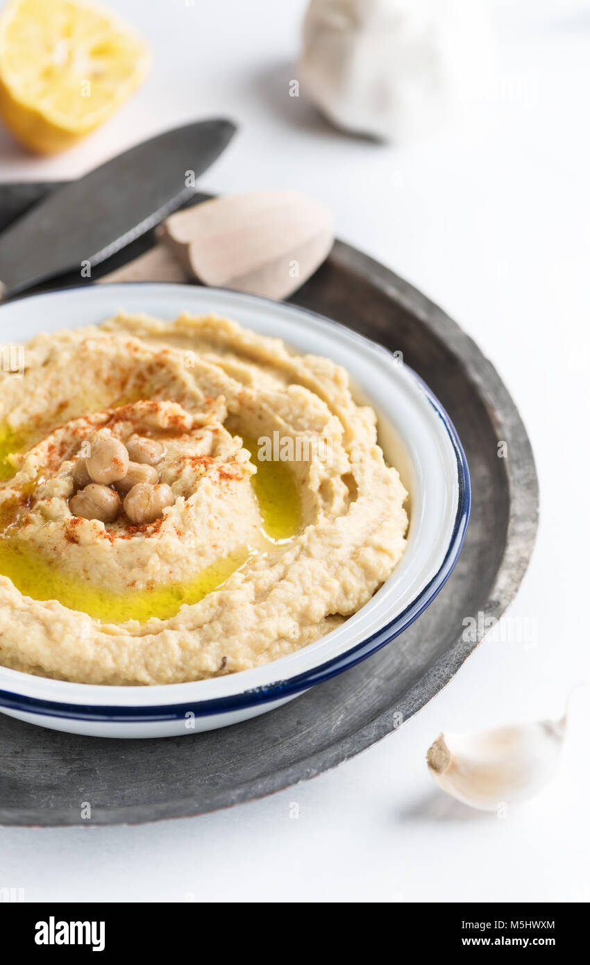 Garbanzo hummus tradicional en un plato con aceite de oliva y pimentón. Foto de stock