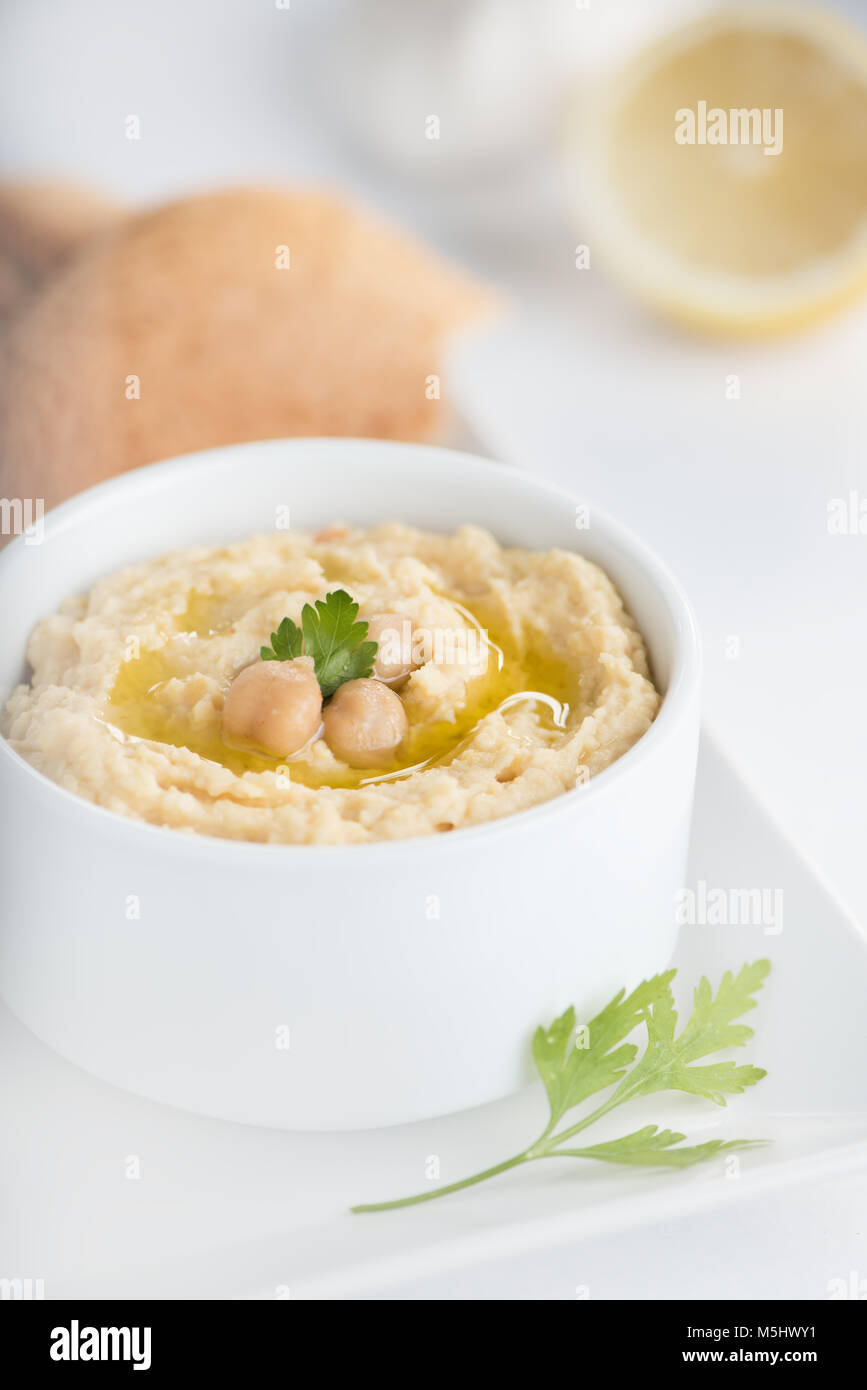 Garbanzo hummus tradicional en un plato con aceite de oliva. Foto de stock