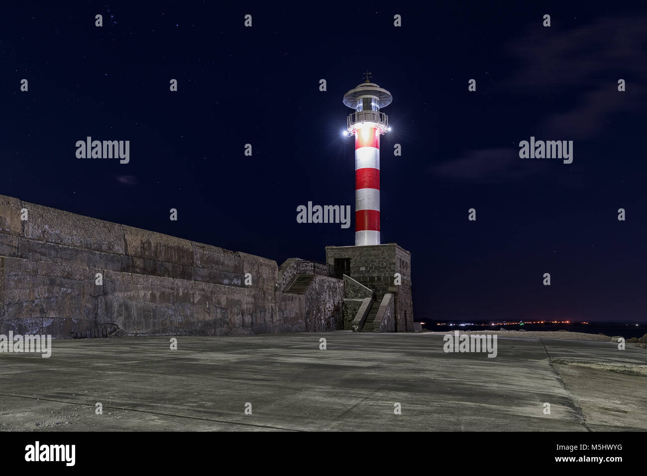 Faro en Burgas, Bulgaria en la noche con estrellas y pocas nubes. Foto de stock