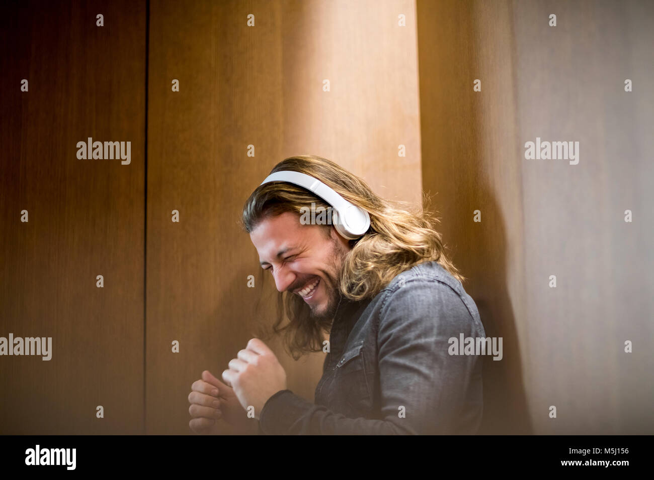 Retrato del hombre emocionado escuchando música con auriculares Foto de stock