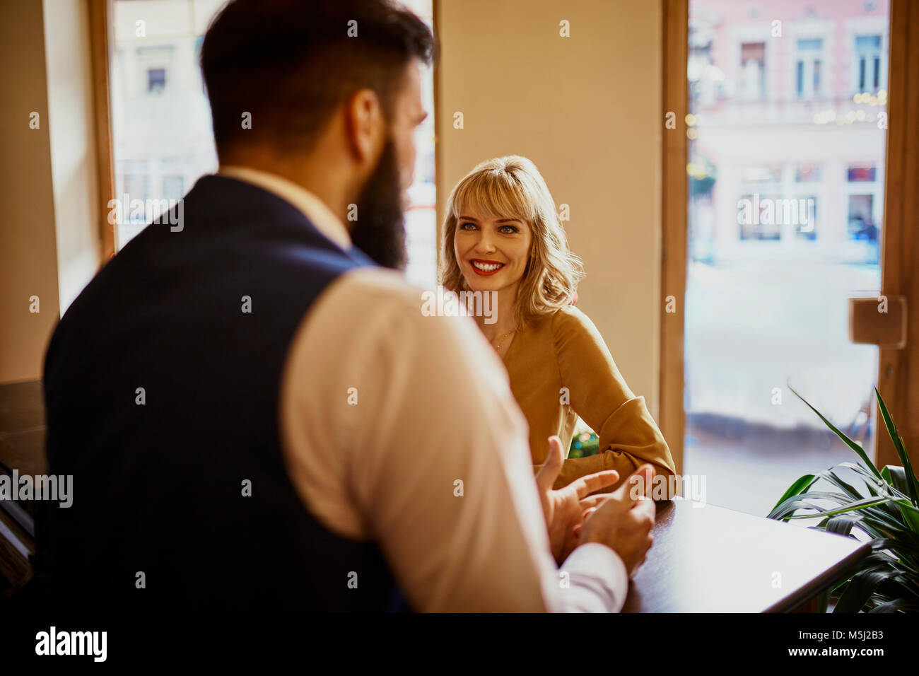 Elegante mujer sonriente al hombre en un bar. Foto de stock