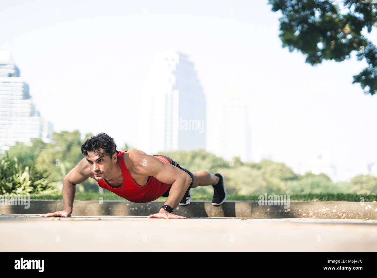 Atleta ejercer push-ups en la ciudad Foto de stock