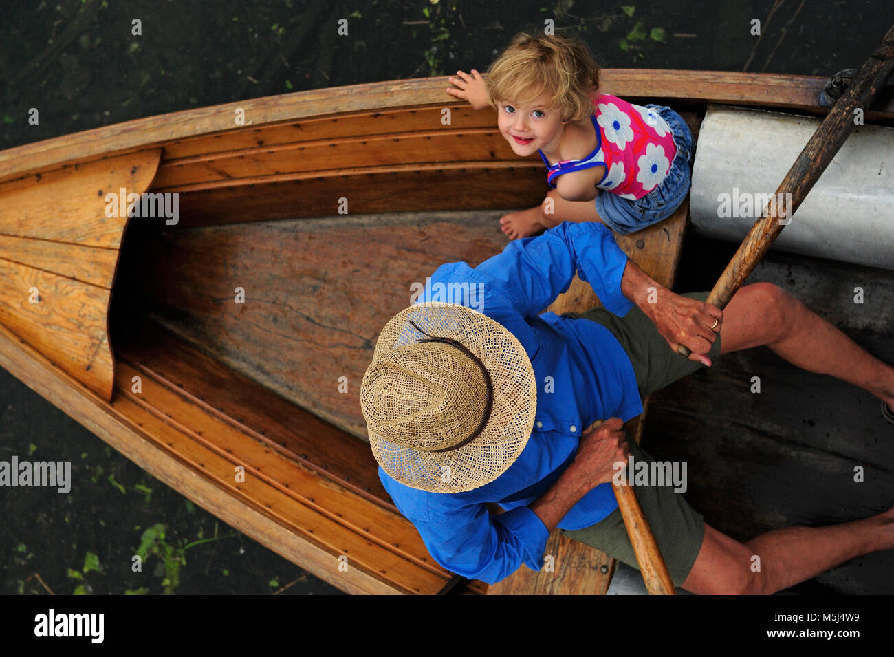 Niña feliz con su abuelo en bote a remo, vista superior Foto de stock