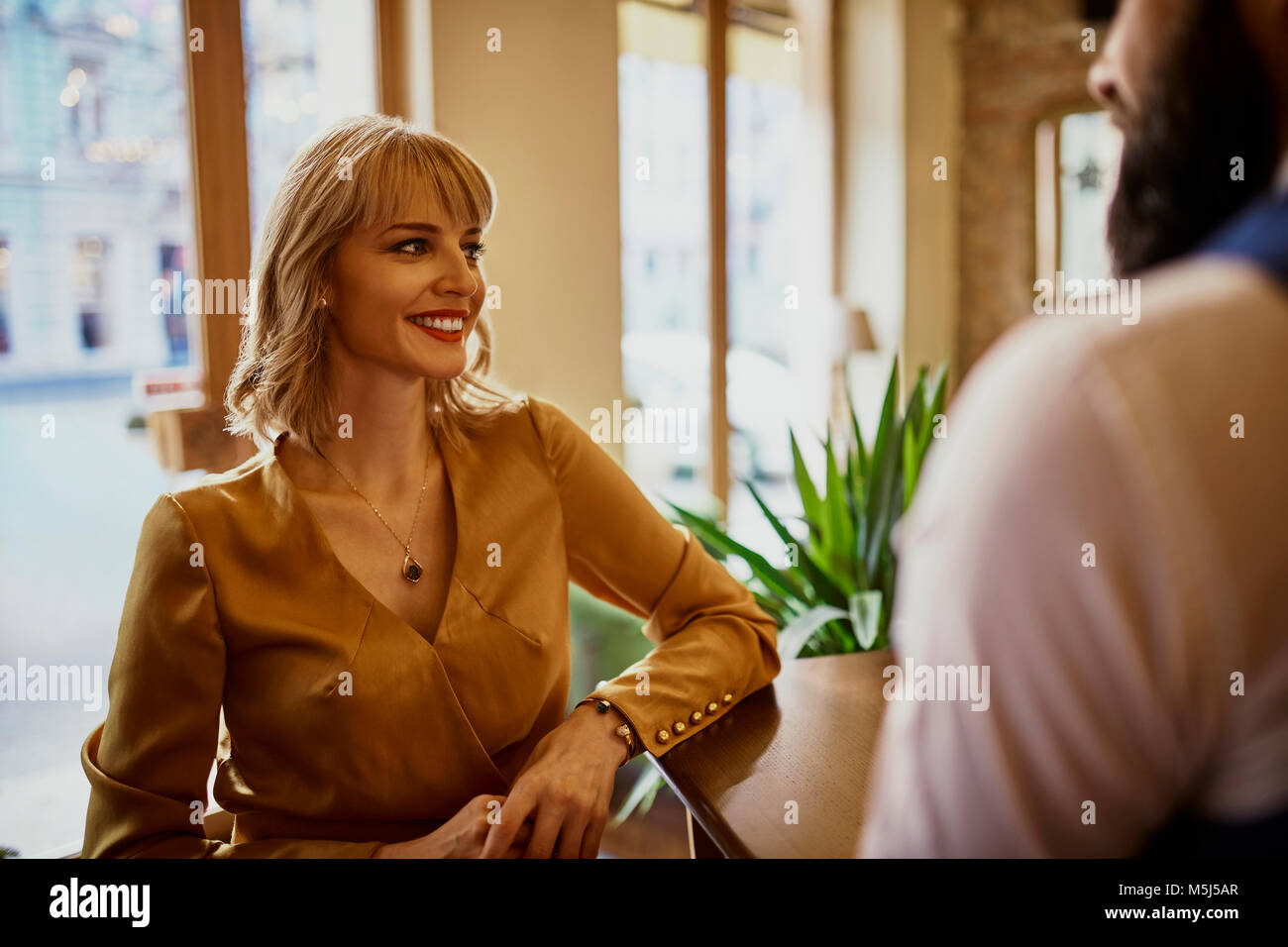 Elegante mujer sonriente con un hombre en un bar. Foto de stock