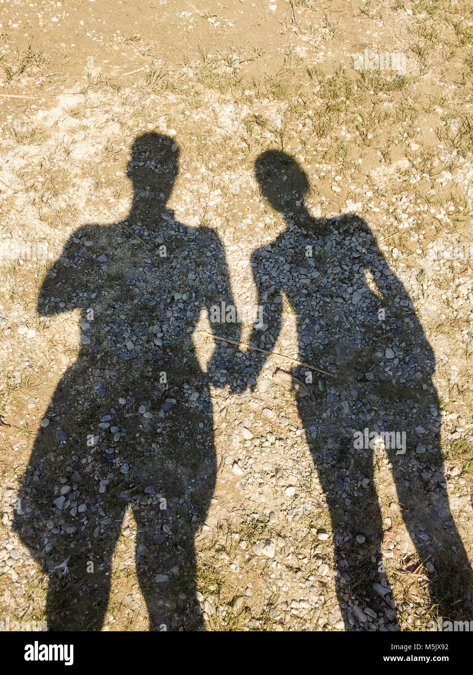 Sombra de una pareja en una playa de guijarros manos Fotografía de stock -  Alamy