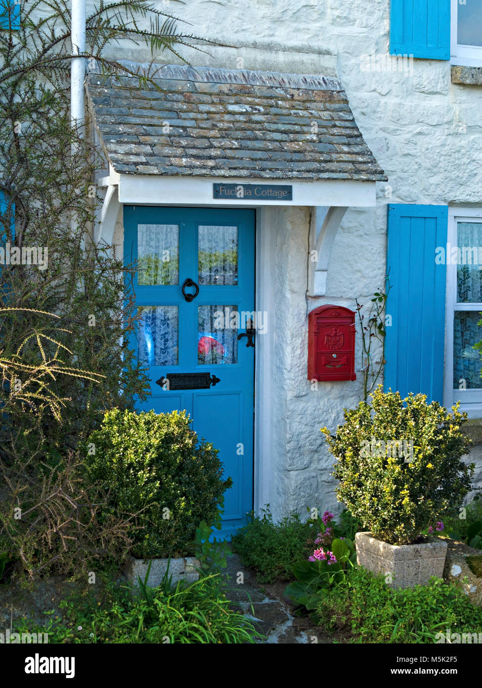 Bonita casa encaladas pintadas de azul con puerta frontal y contraventanas, Mousehole, Cornwall, Inglaterra, Reino Unido. Foto de stock