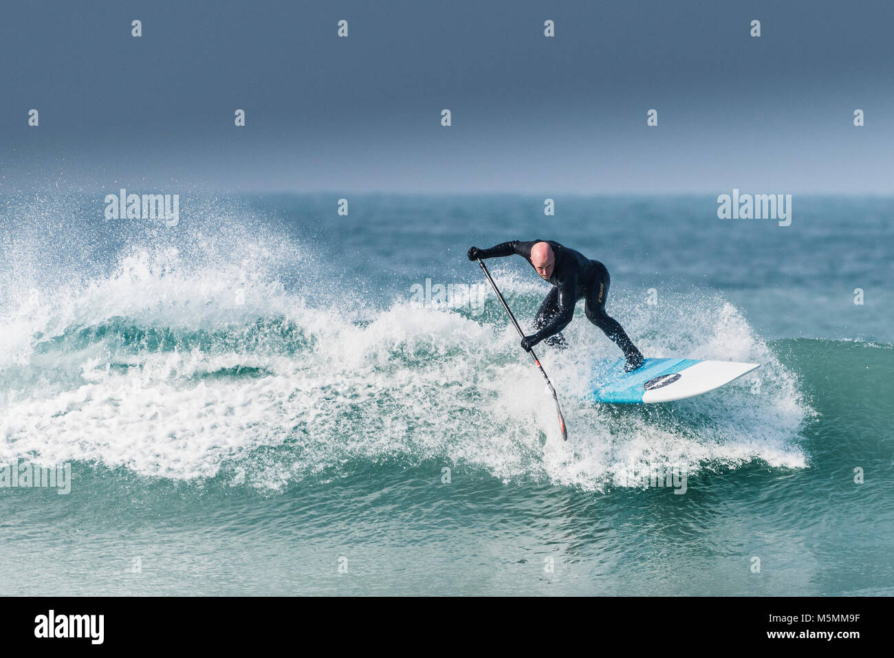 Una paleta boarder montando una onda en Fistral en Newquay, Cornwall. Foto de stock