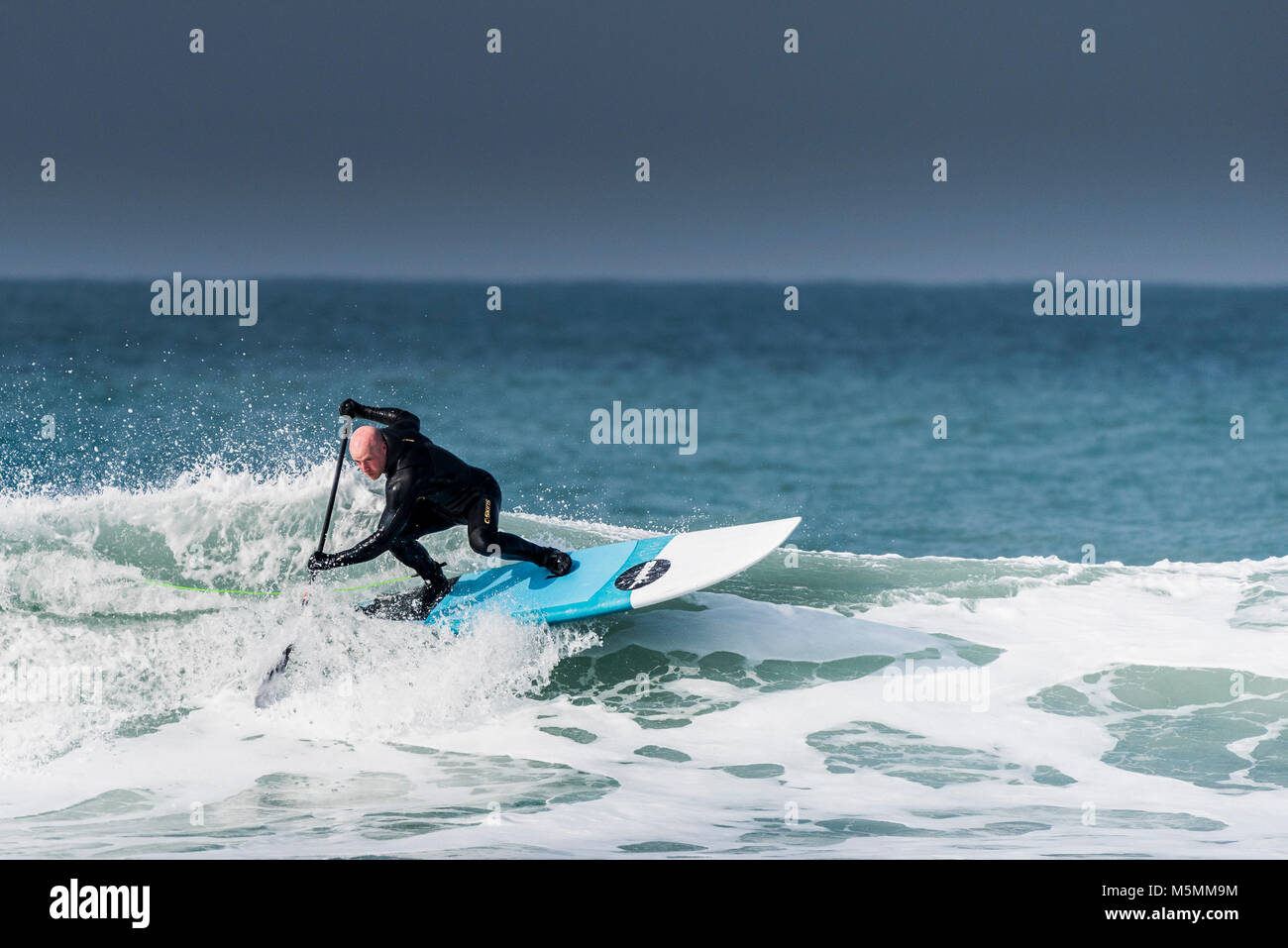 Una paleta boarder montando una onda en Fistral en Newquay, Cornwall. Foto de stock