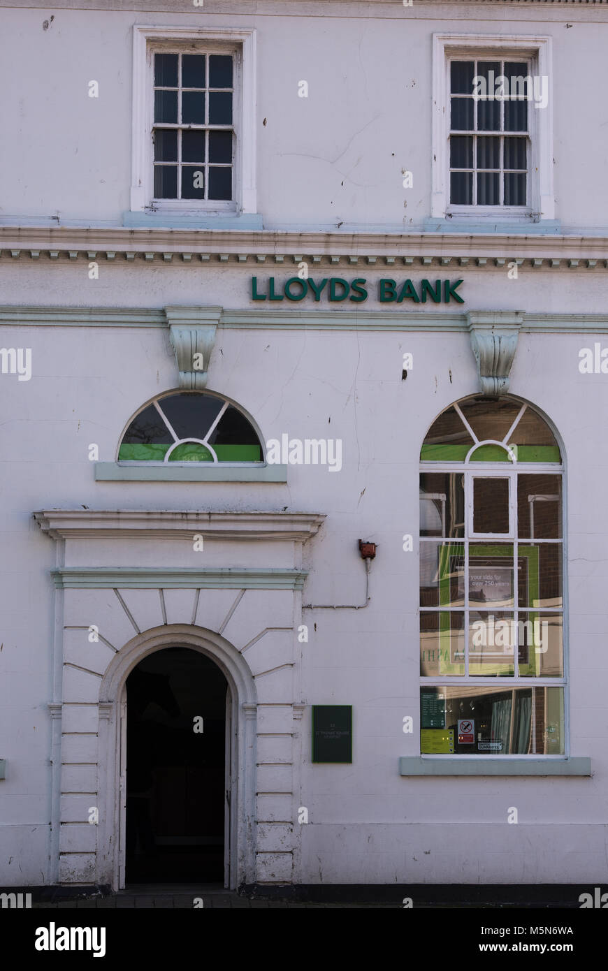 Una rama High Street de Lloyd's Bank convertido en un edificio victoriano con una gran entrada y ventanas de guillotina estilo victoriano. La banca y el centro de la ciudad por carretera. Foto de stock