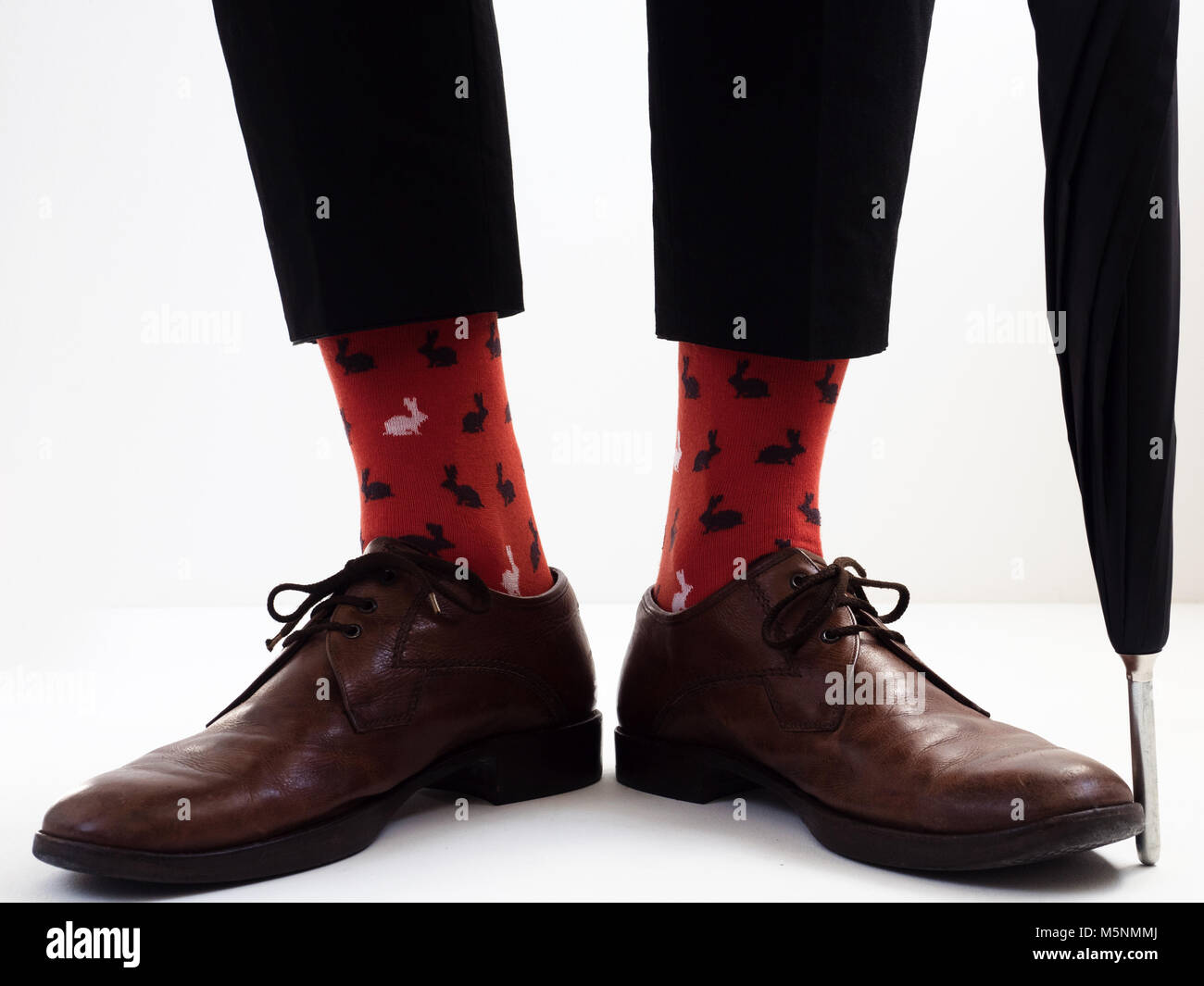Las piernas del hombre en colores brillantes y divertidos calcetines y  zapatos elegantes cerca del paraguas Fotografía de stock - Alamy