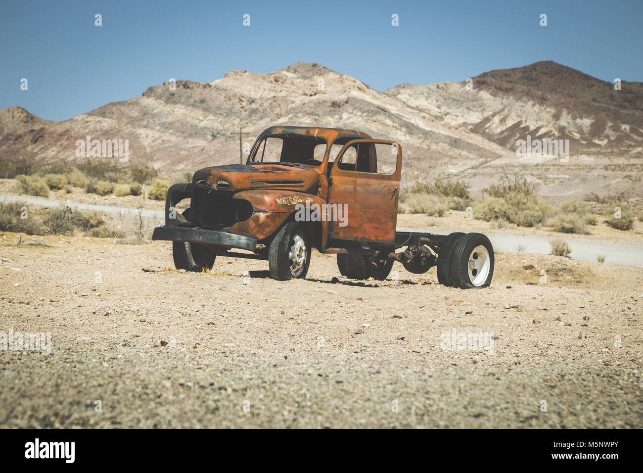 Vista clásica de una vieja camioneta oxidada de un accidente automovilístico en el desierto, en un hermoso día soleado con el cielo azul en verano con filtro vintage retro, EE.UU. Foto de stock