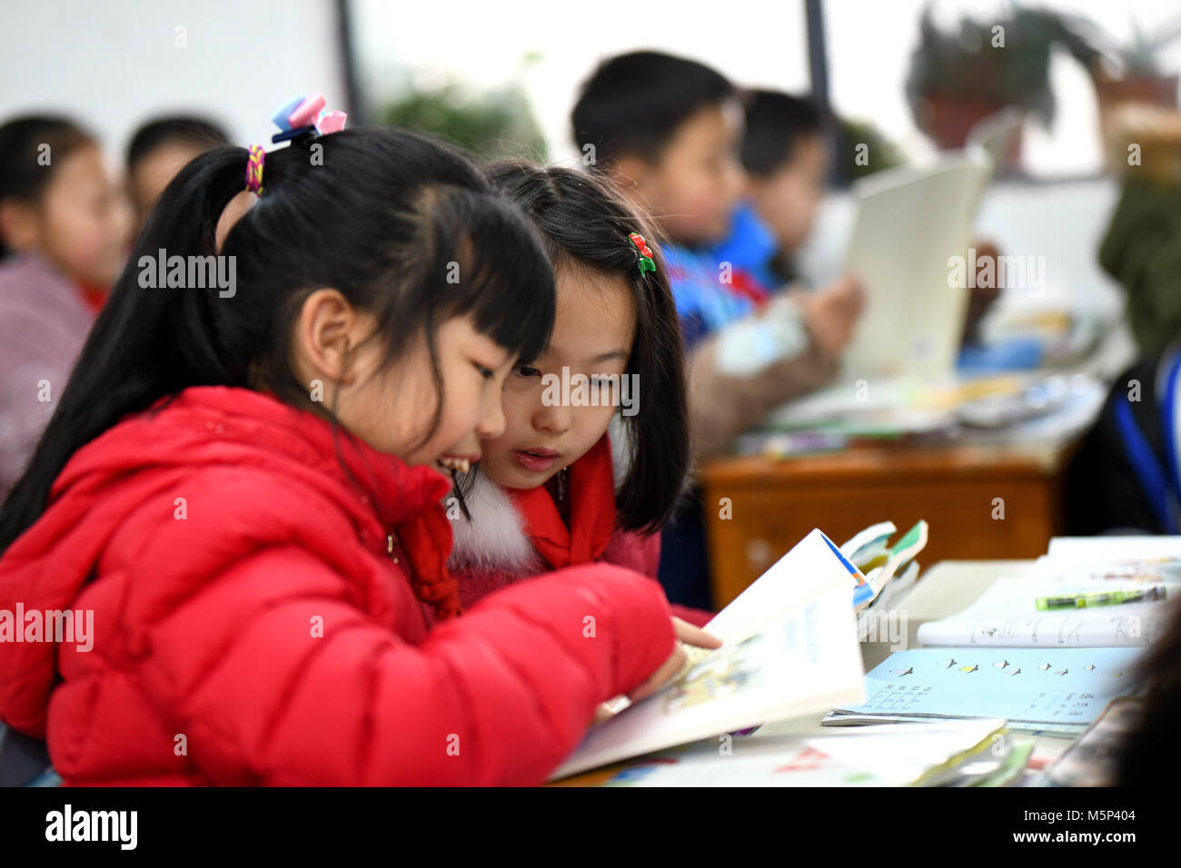 Zunyi. 25 Feb, 2018. Los alumnos de la escuela primaria cultura Zunyi leer los nuevos libros que consiguen en Zunyi, al suroeste de la provincia de Guizhou, China el 25 de febrero de 2018. Los estudiantes regresaron a la escuela y conseguimos nuevos libros de texto para saludar al nuevo semestre. Crédito: Xinhua/Alamy Live News Foto de stock