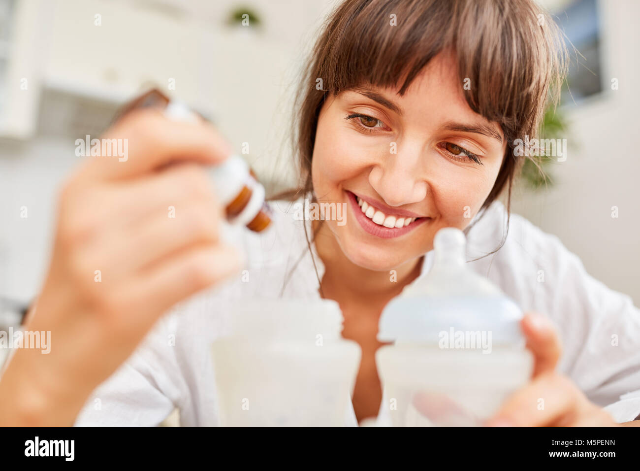 Madre da a gotas para el dolor abdominal como una droga en la comida para bebés Foto de stock