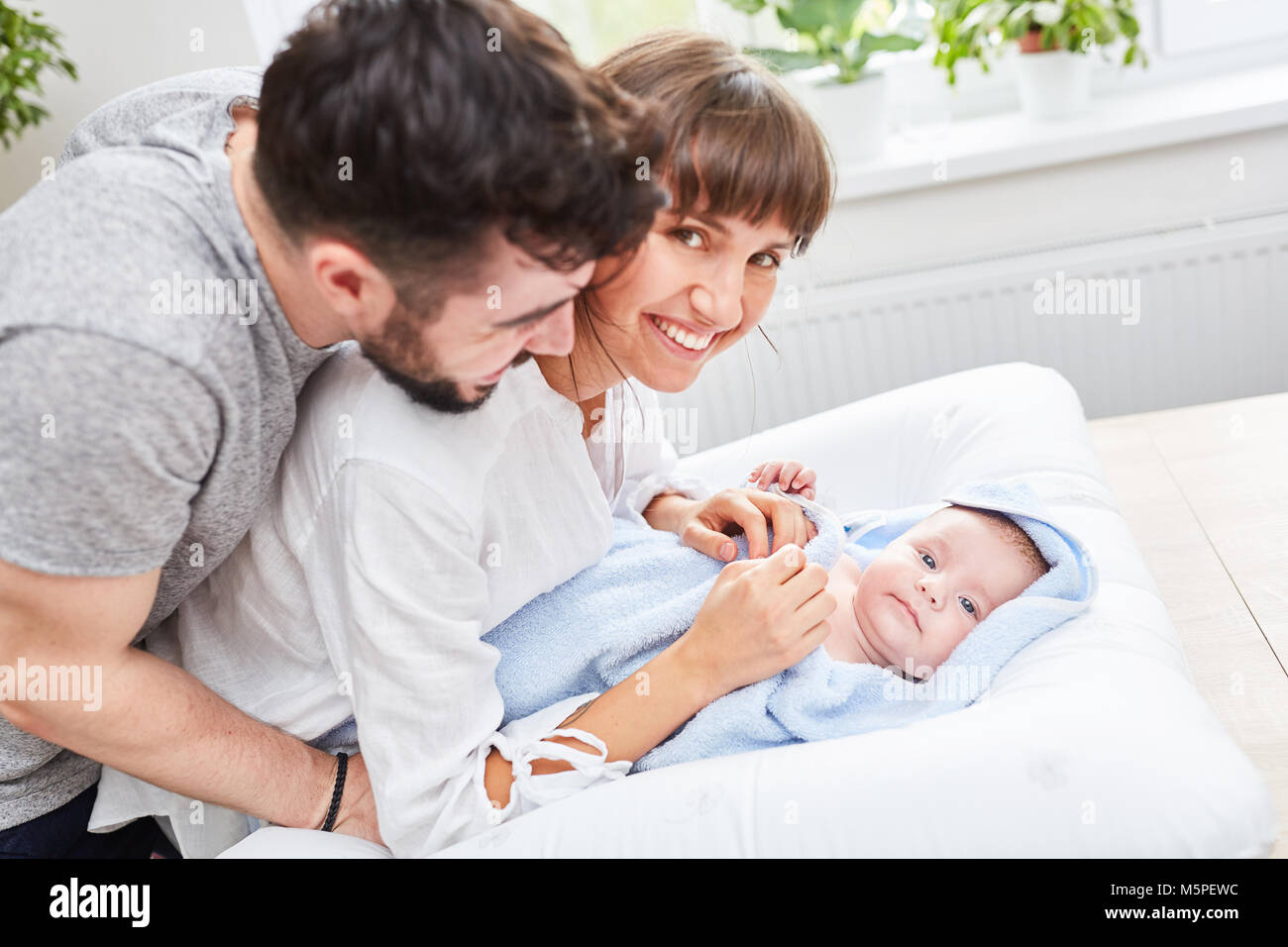 Felices padres están contentos con su bebé envuelta en una toalla Foto de stock