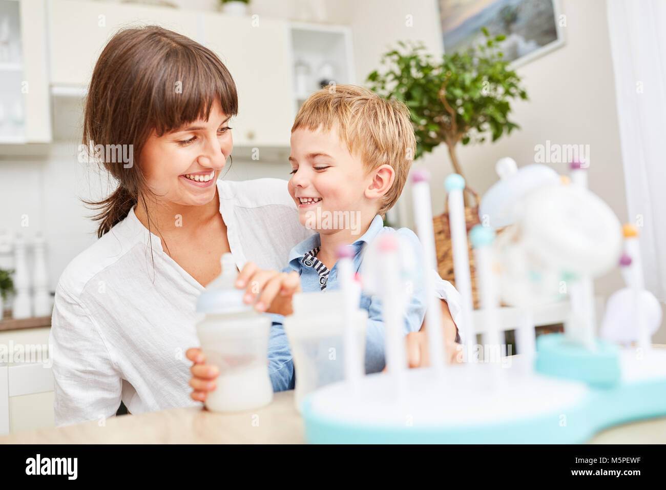 Madre e hijo juntos poner saludable en el bebé alimentos probióticos Foto de stock