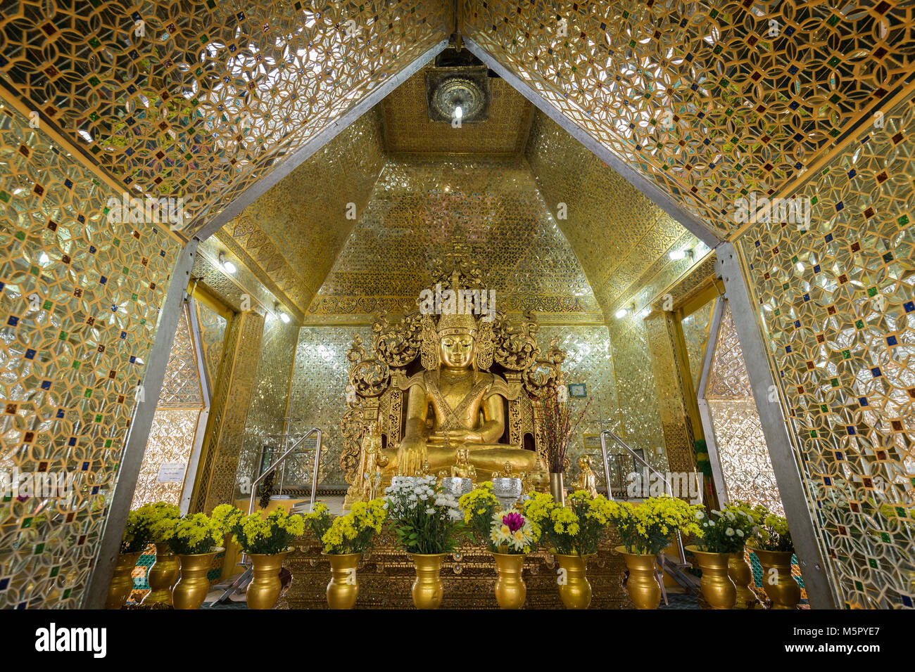 Vista frontal de una estatua dorada de Buda en posición de loto en el interior de la Pagoda Sandamuni en Mandalay, Myanmar (Birmania). Foto de stock