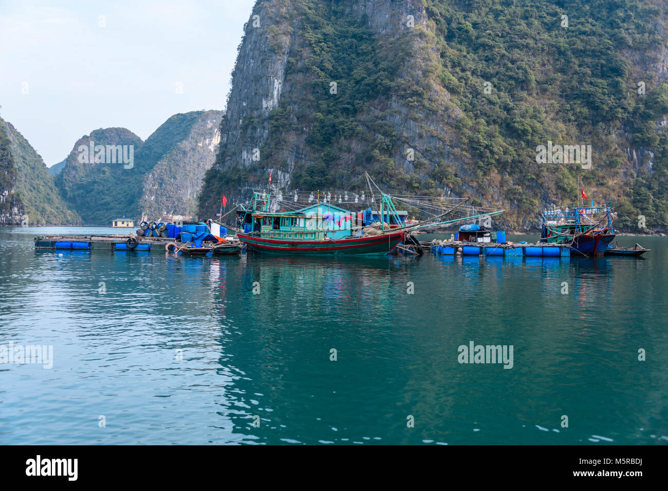 Barco de pesca tradicional vietnamita junto a una plataforma flotante en el  Cua Van pueblo flotante, la Bahía de Halong, Vietnam Fotografía de stock -  Alamy