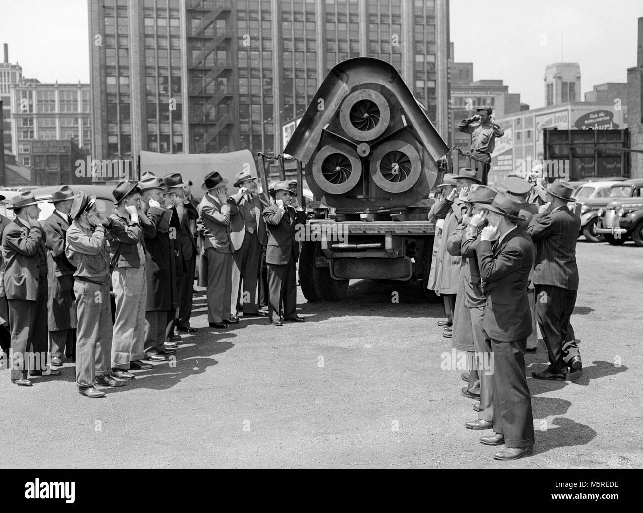 Las orejas están cubiertas por una prueba de sirena de un ataque aéreo durante la II Guerra Mundial en Chicago, ca. 1944. Foto de stock