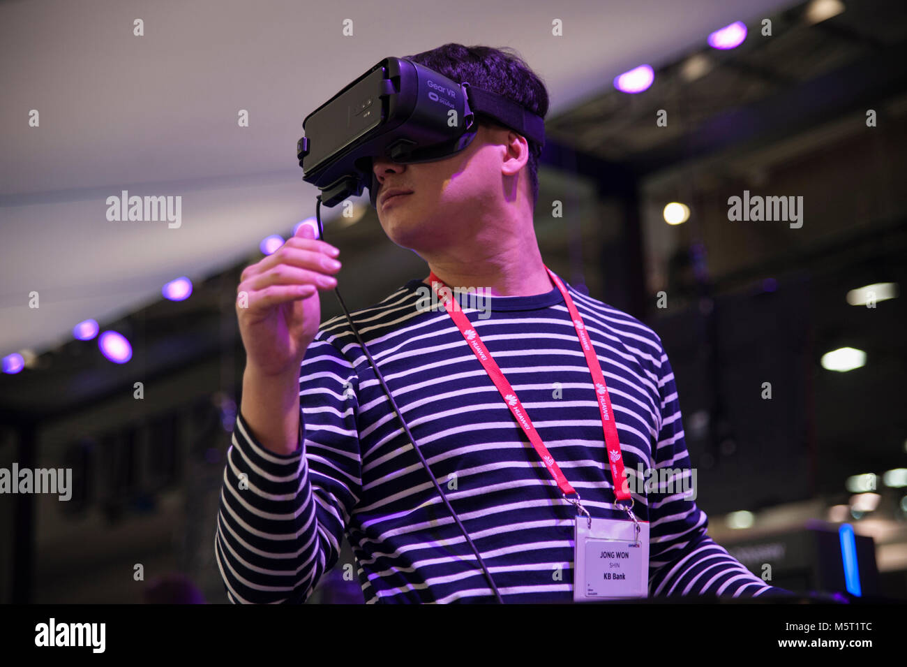 Barcelona, España. 26 Feb, 2018. Un ayudante para el Mobile World Congress Samsung prueba el dispositivo virtual de engranajes, que simula un descenso desde una colina se subió en una tabla de Snowboar. El Mobile World Congress 2018 (MWC), la más importante feria de tecnología móvil en el mundo, celebrado en Barcelona, una vez más, con importantes medidas de seguridad. El congreso comienza este lunes en Barcelona y ha superado el éxito de la pasada edición. Crédito: Charlie Pérez/Alamy Live News Foto de stock