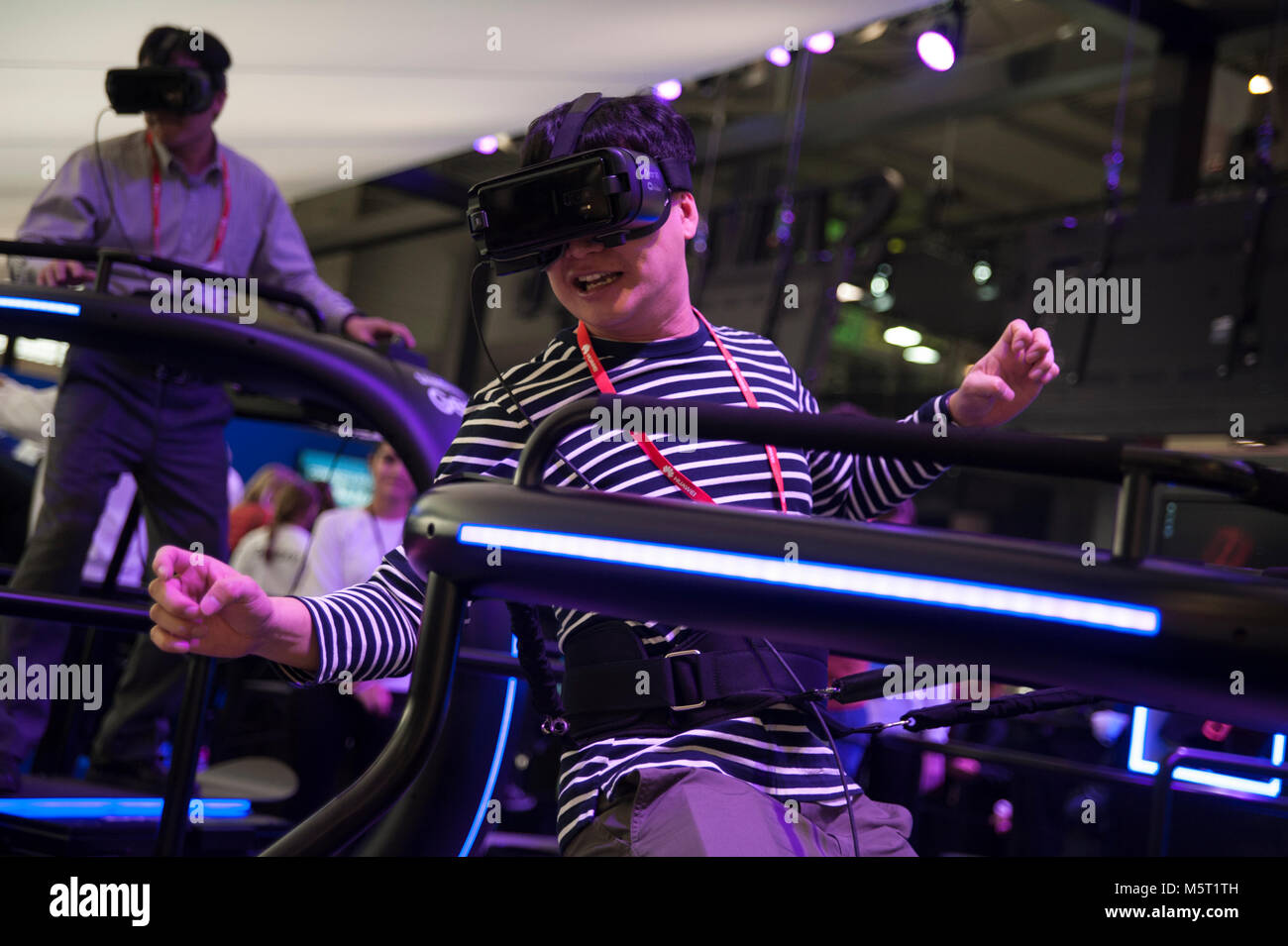 Barcelona, España. 26 Feb, 2018. Un ayudante para el Mobile World Congress Samsung prueba el dispositivo virtual de engranajes, que simula un descenso desde una colina se subió en una tabla de Snowboar. El Mobile World Congress 2018 (MWC), la más importante feria de tecnología móvil en el mundo, celebrado en Barcelona, una vez más, con importantes medidas de seguridad. El congreso comienza este lunes en Barcelona y ha superado el éxito de la pasada edición. Crédito: Charlie Pérez/Alamy Live News Foto de stock