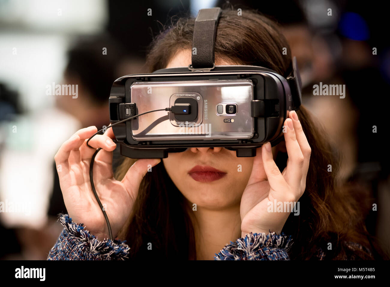 Barcelona, España. 26 de febrero de 2018. Un attende comprueba un VR Engranaje Samsung durante el primer día de la reunión anual de Mobile World Congress, feria móvil más grande del mundo en el que reúne a las principales compañías de móviles y donde las últimas novedades en el sector se presentan. Crédito: Jordi Boixareu/Alamy Live News Foto de stock