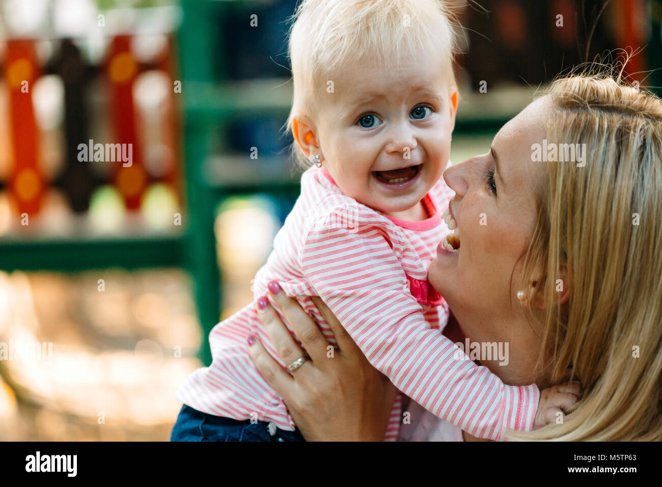 La madre y el bebé feliz besos, riendo y abrazando en la naturaleza al aire libre Foto de stock