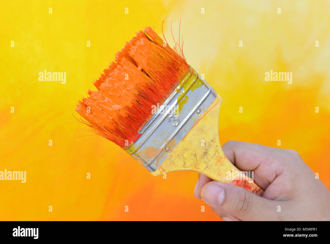 Con la mano en el color de la pintura de pincel mezcla funcione a tiempo  Fotografía de stock - Alamy